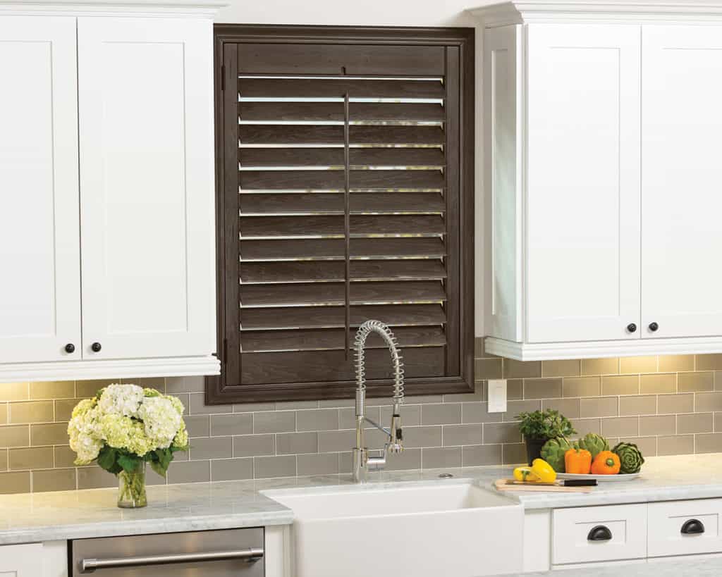 Hunter Douglas Heritance® hardwood shutters provide stunning architectural detail to kitchen windows. Choose a dark stain for rich appearance.